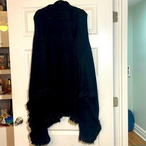 Long black sweater vest with fringe on the bottom.
